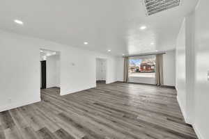 Unfurnished living room with light wood-type flooring, recessed lighting, and a textured ceiling