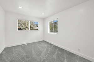 Carpeted empty room featuring baseboards and recessed lighting