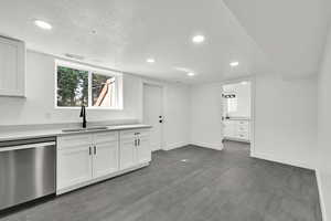 Kitchen with dishwasher, recessed lighting, white cabinetry, a textured ceiling, and dark wood-type flooring