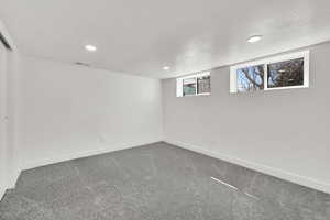 Below grade area with carpet flooring, recessed lighting, and a textured ceiling
