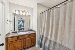 Ensuite bathroom featuring vanity and light tile patterned floors
