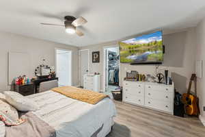 Bedroom featuring luxury vinyl flooring, a spacious closet, and ceiling fan