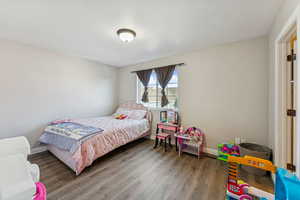 Bedroom featuring baseboards and luxury vinyl floors