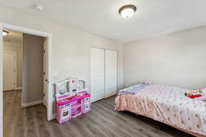 Bedroom featuring luxury vinyl floors and a closet