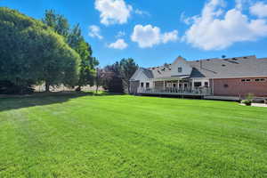 View of grassy yard featuring a deck