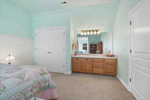 Bedroom with light carpet and a closet