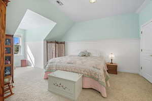 Carpeted bedroom featuring wainscoting, vaulted ceiling, and recessed lighting