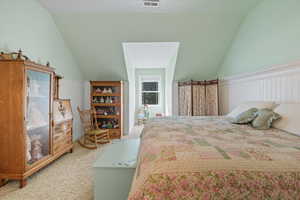 Carpeted bedroom featuring vaulted ceiling