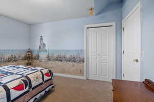 Bedroom featuring carpet floors, a closet, and lofted ceiling