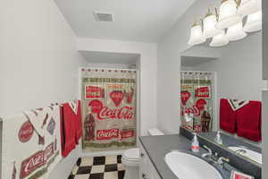 Bathroom featuring tile patterned floors, vanity, and a shower with curtain