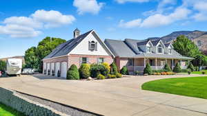 View of front of house featuring driveway, brick siding, a porch, a garage, and roof with shingles