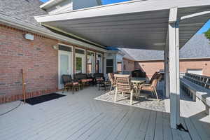 Wooden terrace with outdoor dining area and grilling area