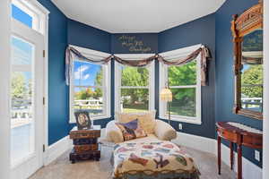 Reading area of the Primary Suite Bedroom with carpet and baseboards