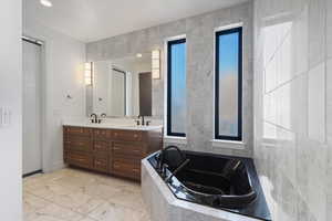 Bathroom featuring double vanity, and bath