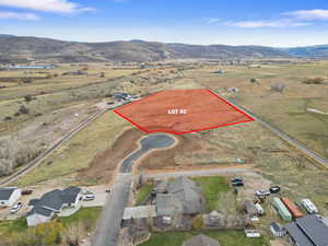 Aerial view of sparsely populated area with a mountain backdrop and property parcel outlined