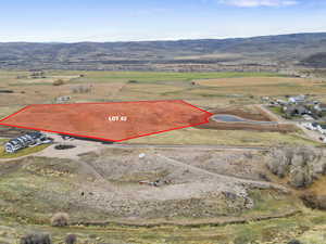 Aerial view of sparsely populated area with property boundaries highlighted and a mountain backdrop