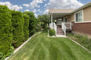 View of grassy yard with a porch