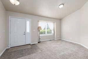 Carpeted foyer entrance featuring baseboards