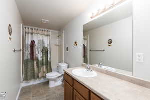 Bathroom featuring shower / bath combo with shower curtain and vanity