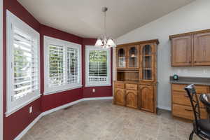 Dining room featuring vaulted ceiling and a chandelier