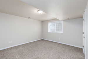 Spare room with light carpet and a textured ceiling