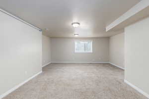 Spare room featuring light colored carpet and a textured ceiling