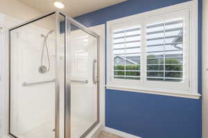 Bathroom with a stall shower and light tile patterned flooring