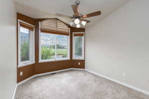 Carpeted empty room featuring ceiling fan and a mountain view