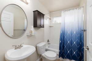 Bathroom with shower / bath combo with shower curtain and toilet