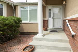Doorway to property featuring stucco siding