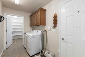 Laundry room with cabinet space, washing machine and dryer, and a textured ceiling