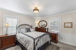 Bedroom with light carpet and ornamental molding