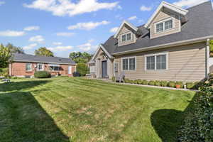 Cape cod home with a front lawn and roof with shingles