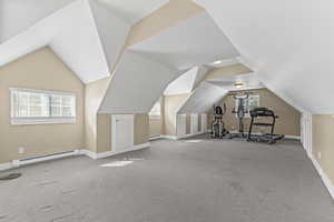 Bonus room with baseboard heating, vaulted ceiling, carpet flooring, and a baseboard radiator