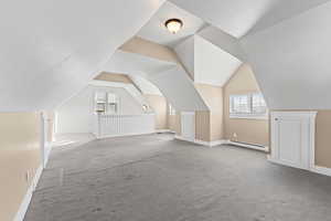 Bonus room featuring lofted ceiling, a baseboard heating unit, and carpet