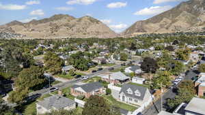 Aerial view of property and surrounding area featuring nearby suburban area and a mountainous background