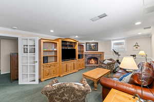 Living area with crown molding, a fireplace, carpet flooring, and recessed lighting