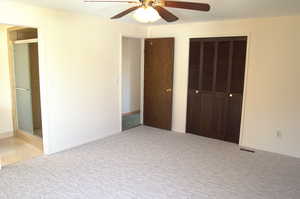 Unfurnished bedroom featuring light carpet and ceiling fan