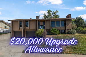 View of front of house featuring an attached garage, a chimney, and driveway