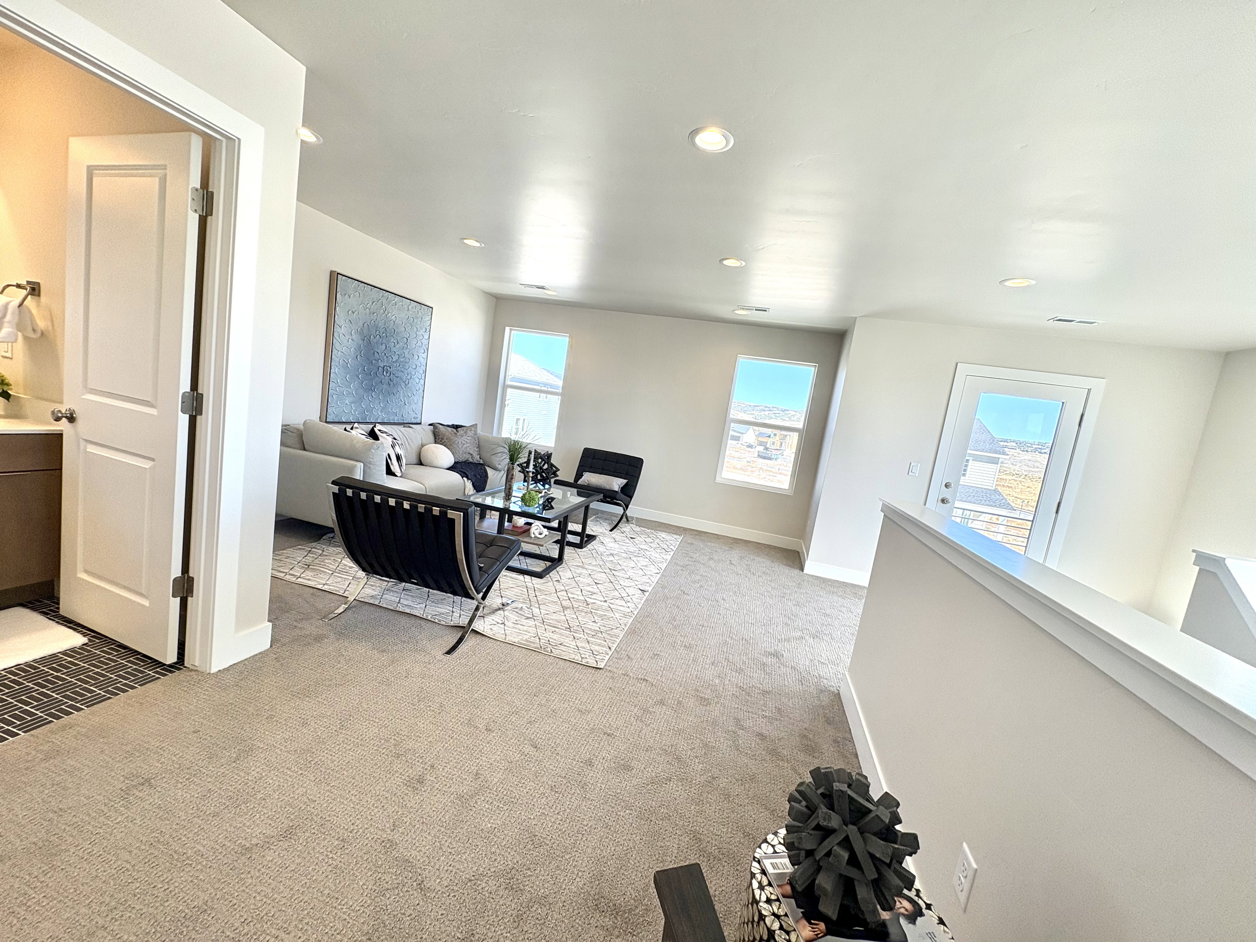 Living area with light carpet, healthy amount of natural light, and recessed lighting