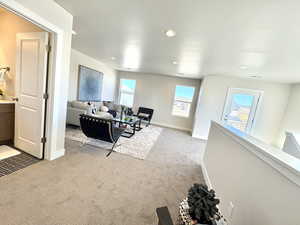 Living area with light carpet, healthy amount of natural light, and recessed lighting