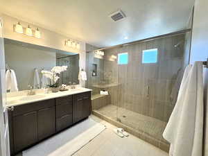 Full bathroom with light tile patterned floors, a stall shower, double vanity, and recessed lighting