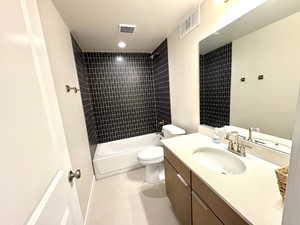 Bathroom with vanity, bathing tub / shower combination, and light tile patterned floors
