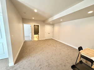 Basement with recessed lighting and light colored carpet