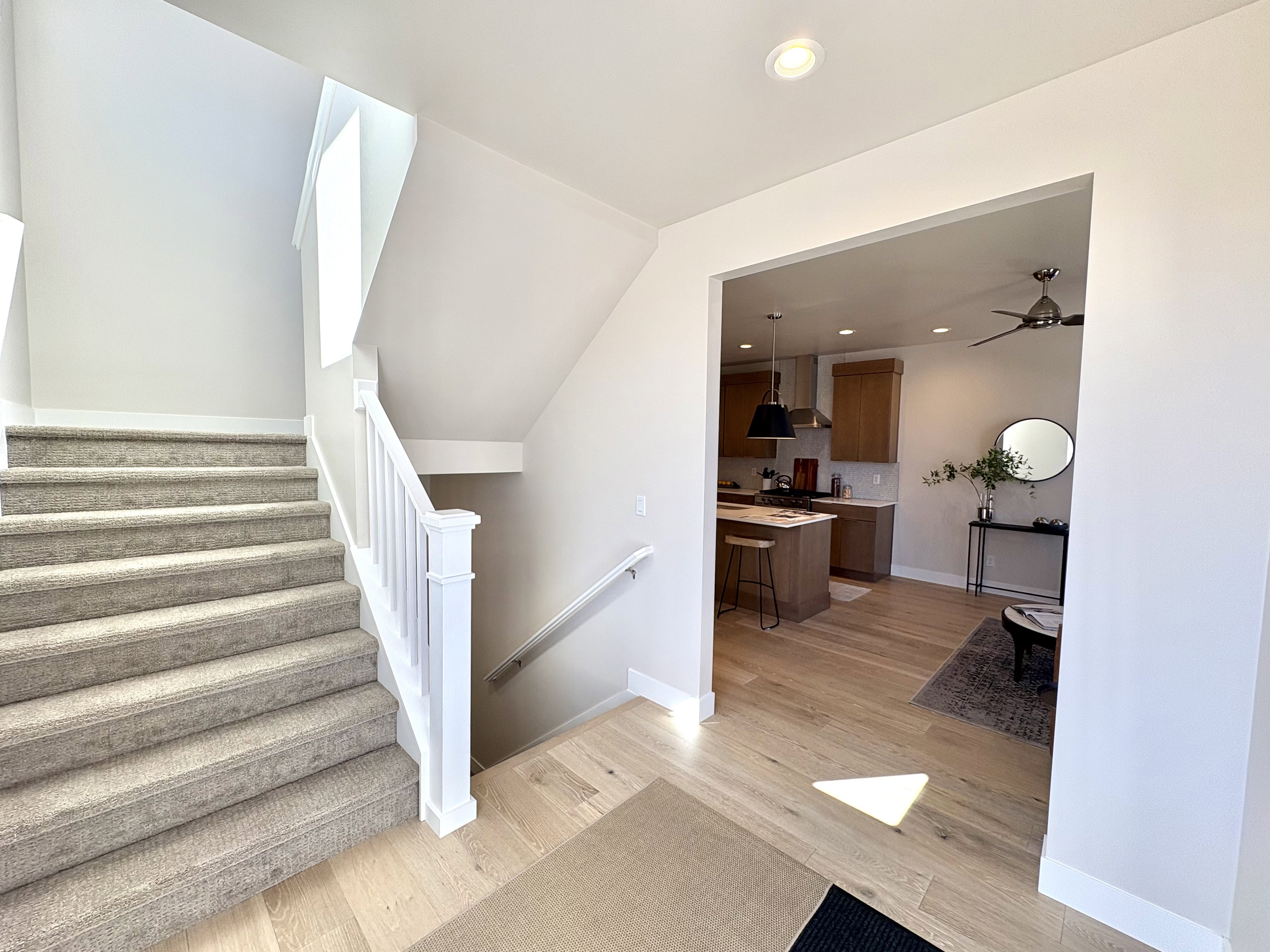 Staircase with recessed lighting and wood finished floors