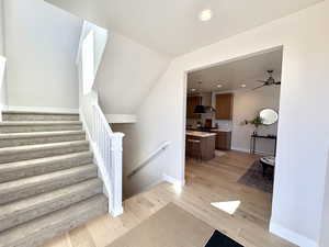Staircase with recessed lighting and wood finished floors
