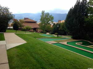 View of property's community featuring a yard, a putting area, and a mountain view
