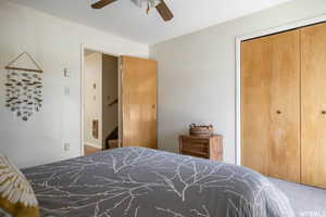 Bedroom with a closet, carpet, and a ceiling fan