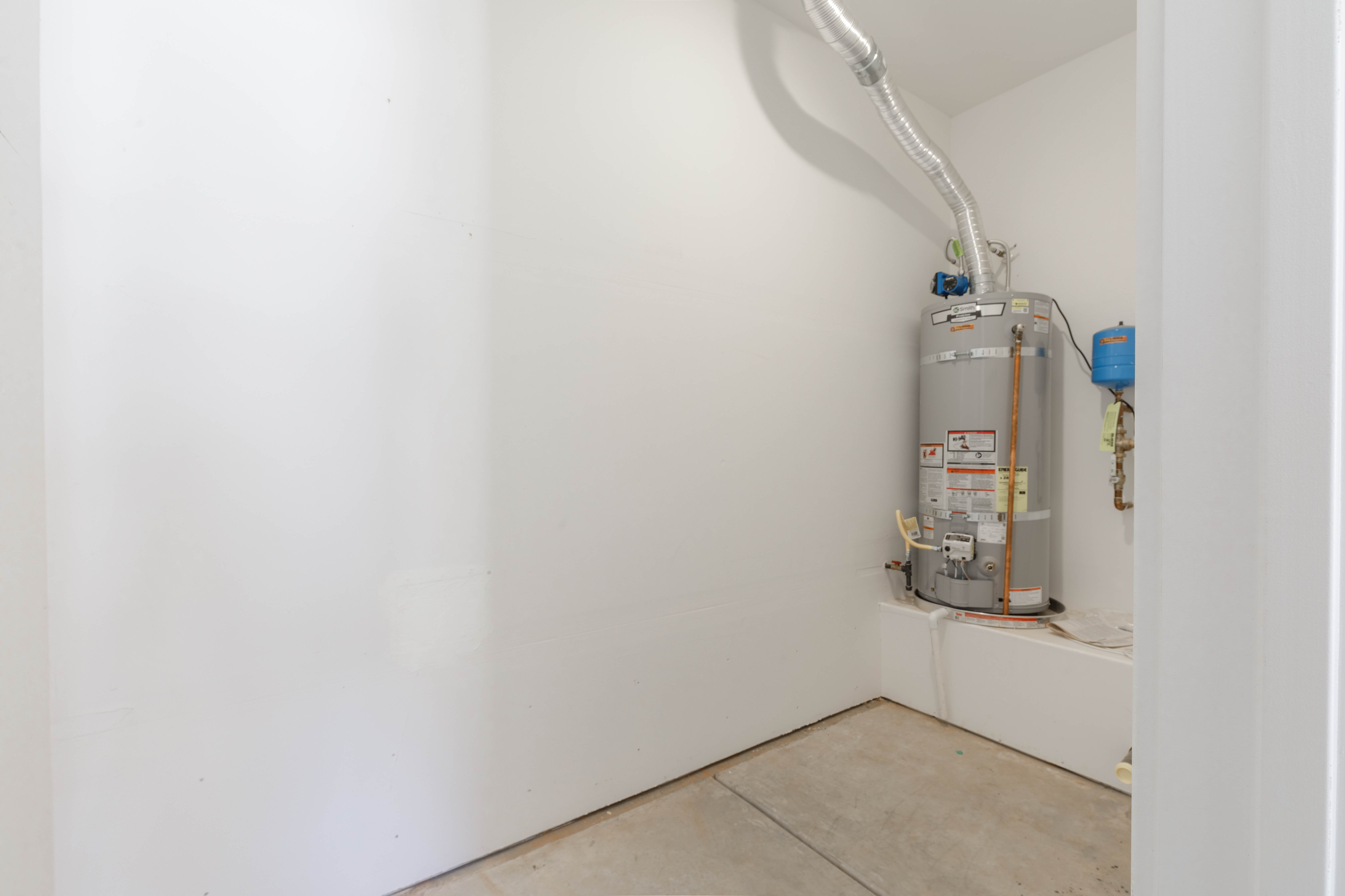 Closed in storage room at the back of 3rd car garage with water heater.