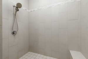 Owners Suite shower, tile with large bench seat and glass entry door.